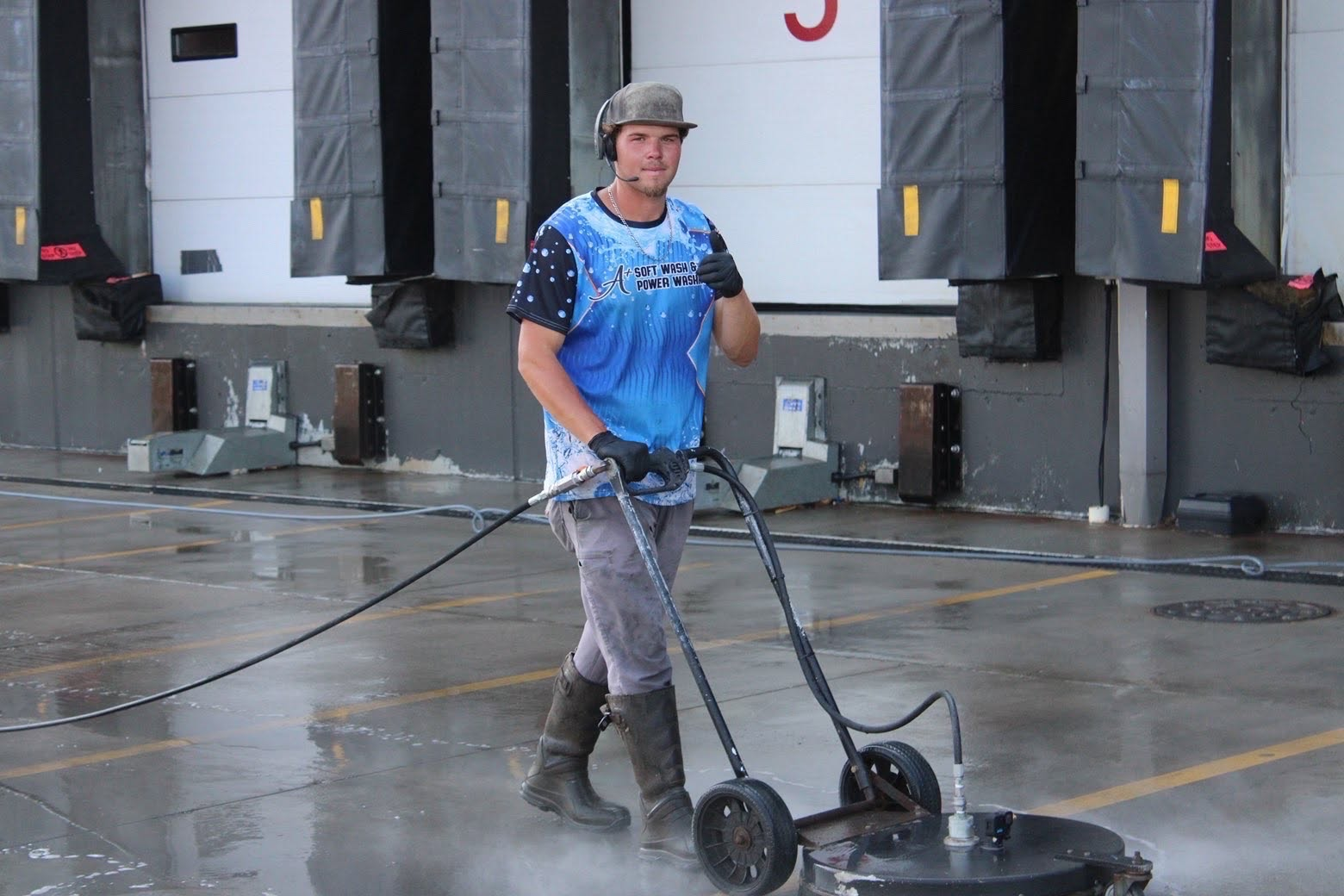 Ashton Duff, owner and operator of A+ Pressure Washing, pressure washing a commercial loading dock